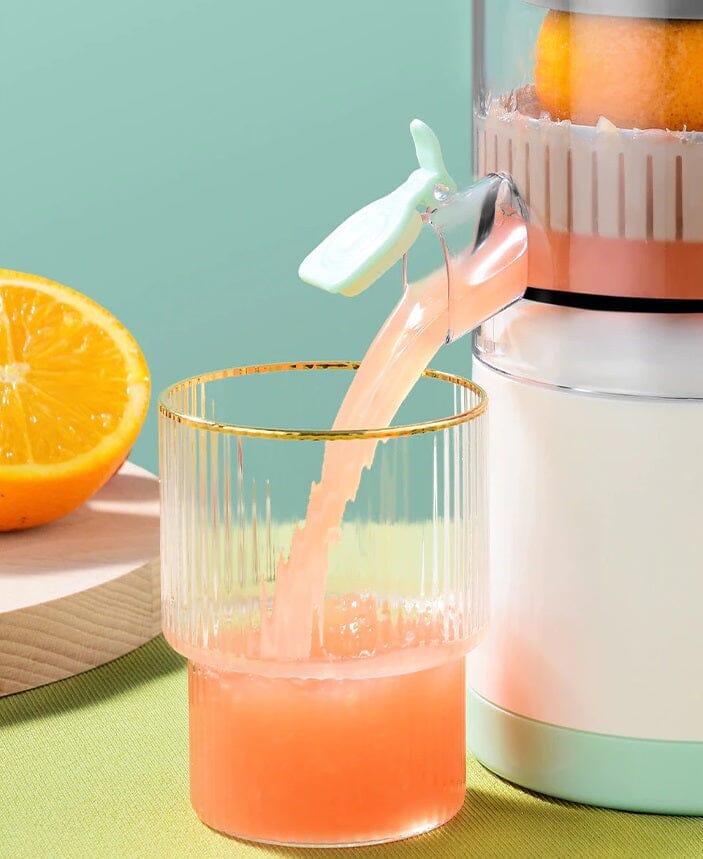 exprimidor eléctrico de frutas portátil Tendeli Ecuador vertiendo zumo de naranja en vaso de vidrio